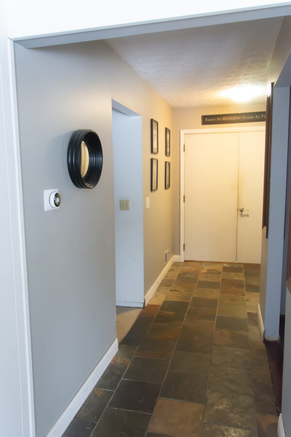 before photo of a foyer with gray green walls and slate tile