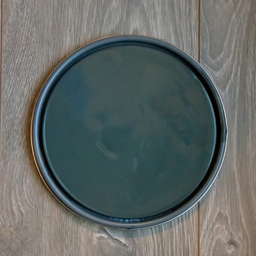 Paint can lid with dark blue-green paint color